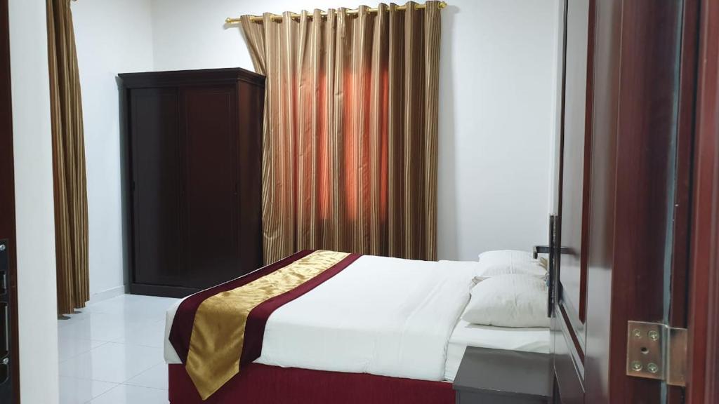 苏尔Sea Hotel Apartment的一间卧室配有床和窗帘