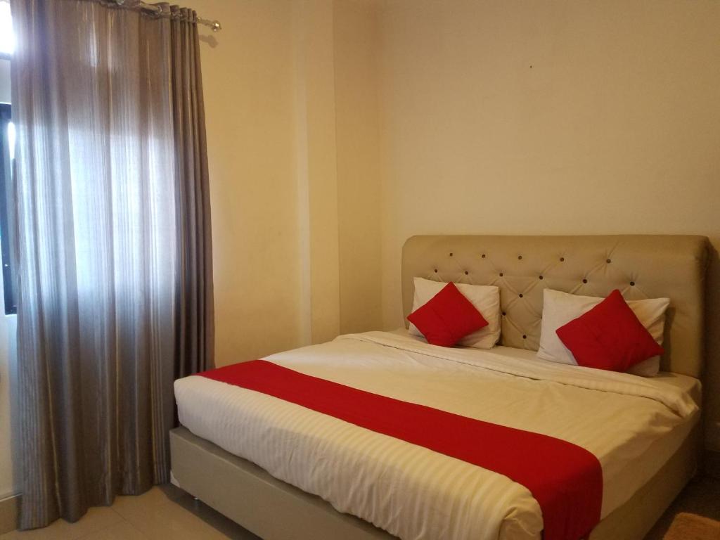 武吉丁宜Mina Homestay Syariah的一间卧室配有红色和白色枕头的床