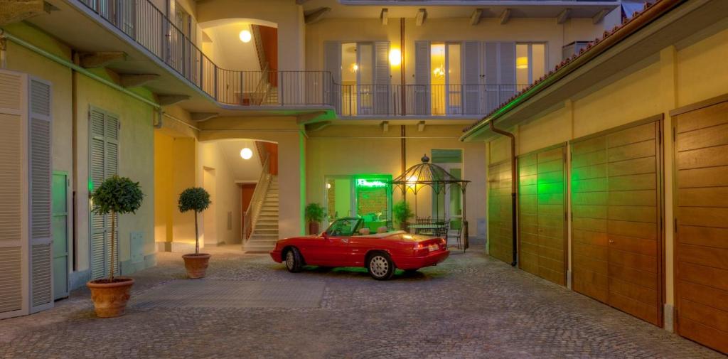 都灵Santa Giulia Hotel e Residence Torino的停在大楼停车场的红色汽车