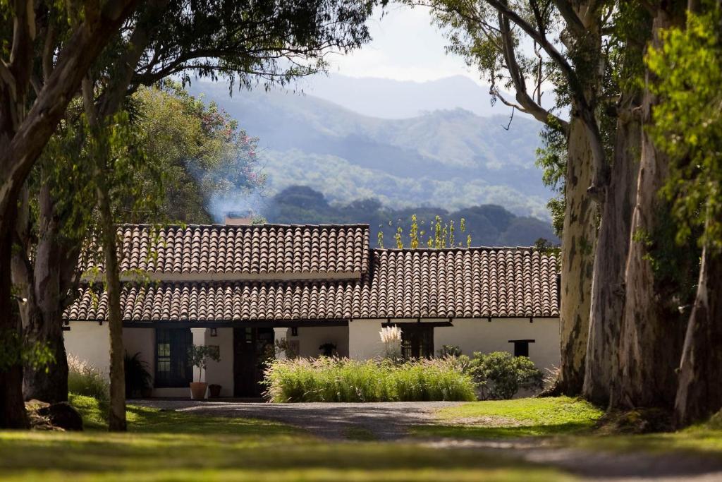 El EncónHouse of Jasmines Relais & Châteaux的一座白色的建筑,屋顶上以群山为背景