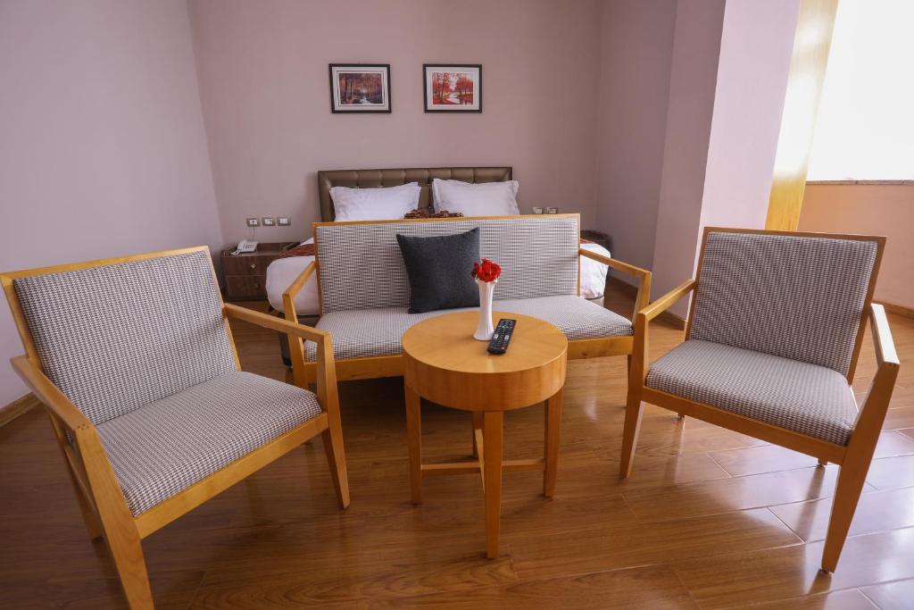 亚的斯亚贝巴New Day Hotel的客厅配有两把椅子、一张桌子和一张床