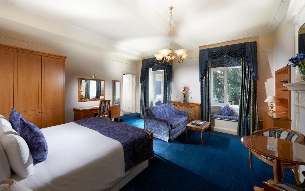 圣彼得港莱斯罗科特酒店的酒店客房带一张床、一张桌子和椅子