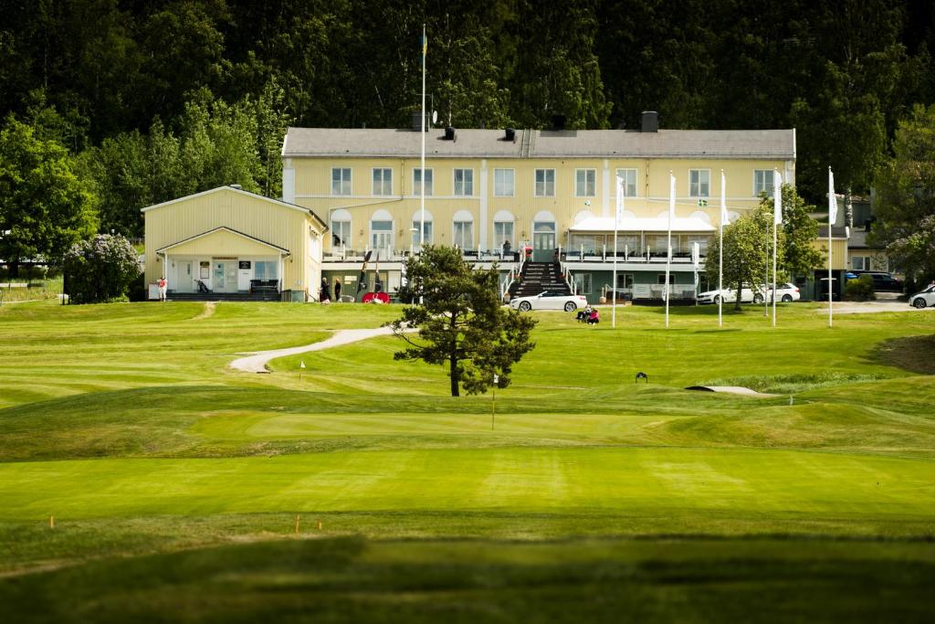 恩舍尔兹维克Hotell Veckefjärden的享有高尔夫球场和大楼的景色