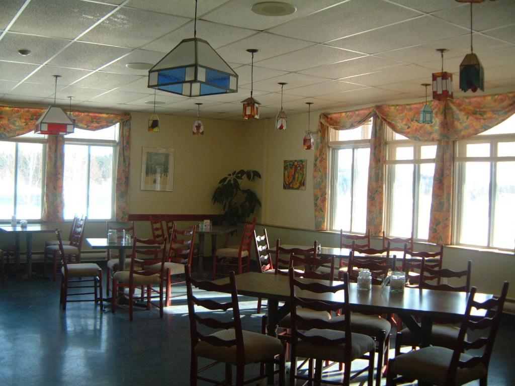 翁弗勒Auberge Île du Repos的用餐室设有桌椅和窗户。