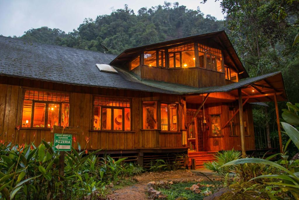 明多Mindo Garden Lodge and Wildlife Reserve的一座大型木制房子,有很多窗户