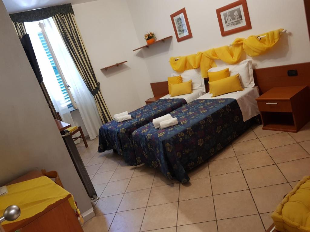 诺瓦拉卡瓦略比安科酒店的一间卧室配有两张床和黄色枕头