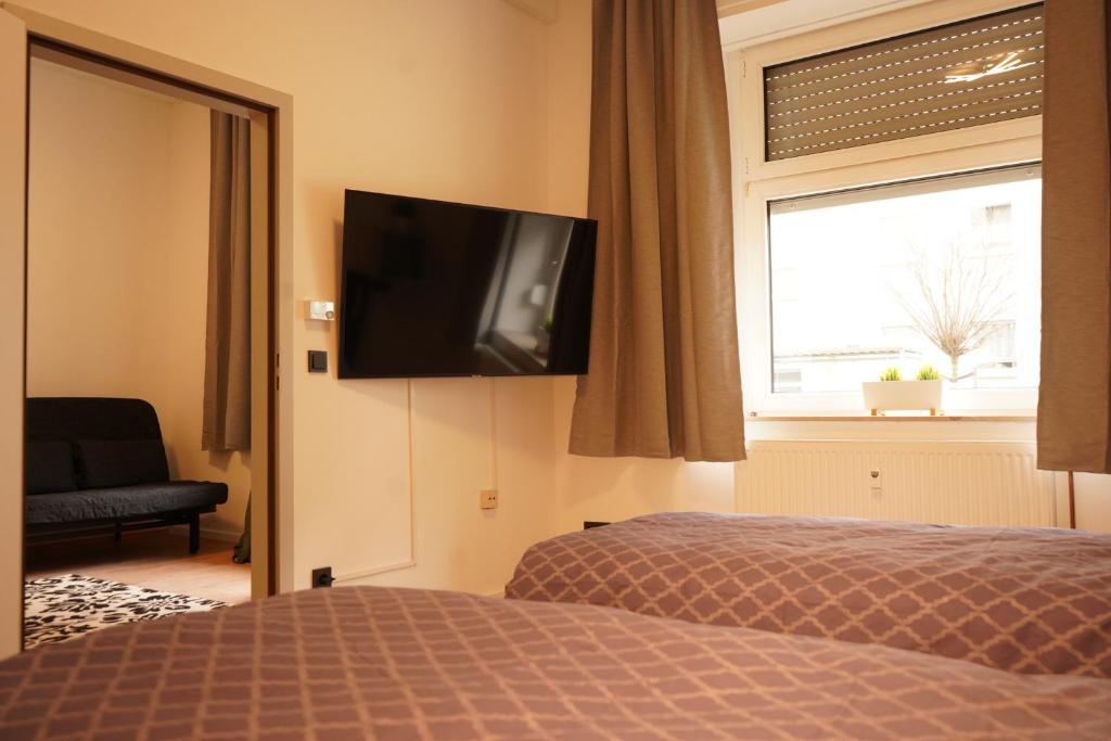 赫恩Vivo Apartments at Hospitals的卧室配有一张床,墙上配有电视