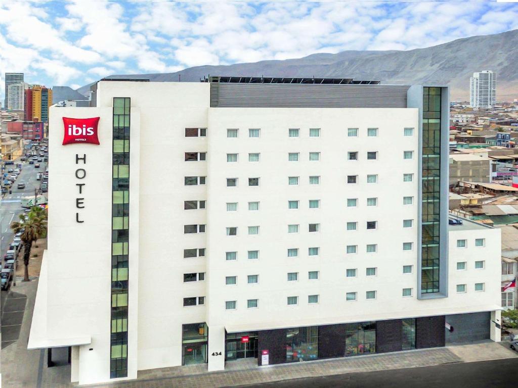 伊基克ibis Iquique的白色的建筑,上面有酒店的标志