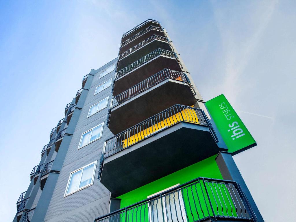 布林迪西Ibis Styles Brindisi的一座高大的绿色和黑色建筑