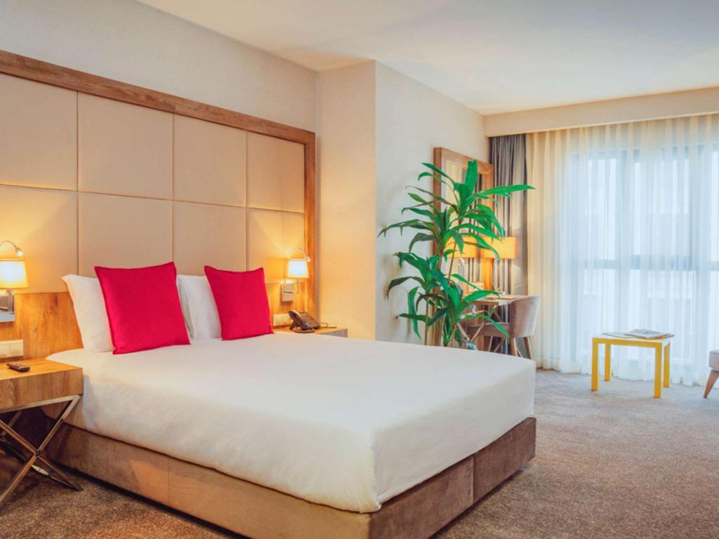 伊斯坦布尔伊斯坦布尔博蒙蒂宜必思尚品酒店的一间卧室配有一张带红色枕头的大床