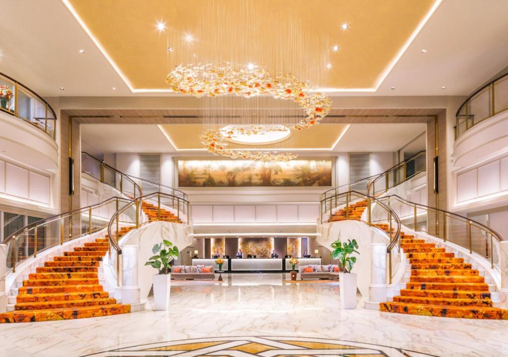 新加坡新加坡史各士皇族酒店的大堂设有楼梯和吊灯。