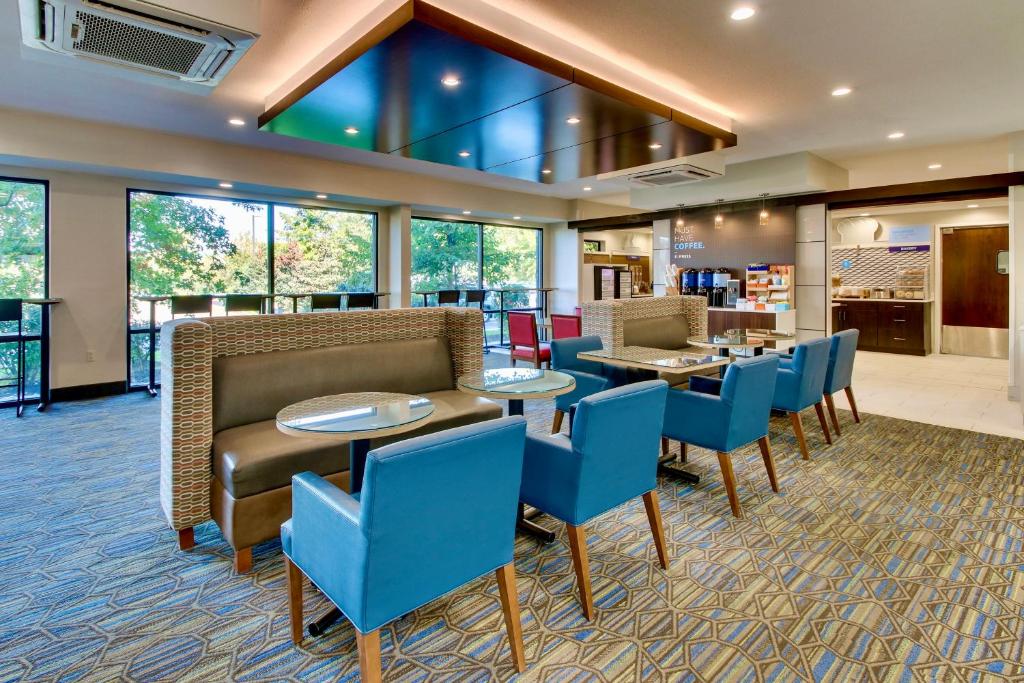 菲什基尔Holiday Inn Express Fishkill, an IHG Hotel的酒店大堂设有桌子和蓝色椅子。