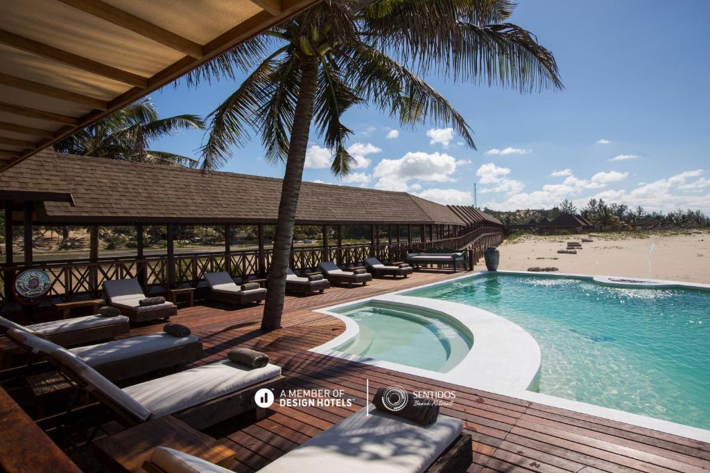 MiramarSentidos Beach Retreat的一个带躺椅的游泳池和海滩