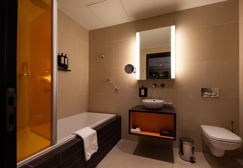 赖斯韦克Hotel & Spa Savarin - Rijswijk, The Hague的带浴缸、盥洗盆和卫生间的浴室