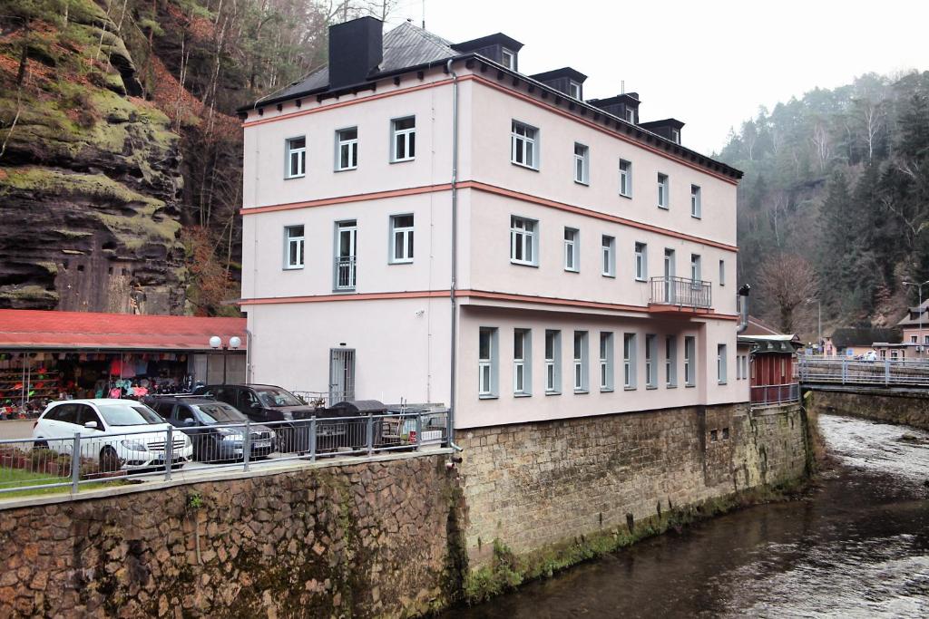 赫任斯科Hotel Kotva的河边的墙上的白色建筑