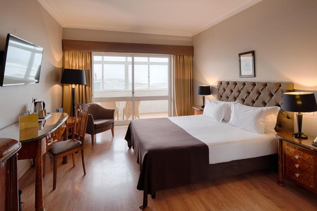 加亚新城Golden Tulip Porto Gaia Hotel的酒店客房设有一张大床和一张书桌。