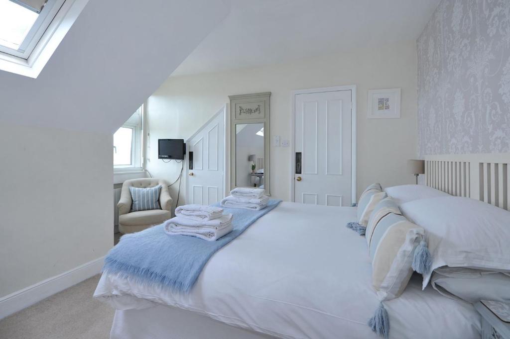 巴斯Abbey Rise bed and breakfast的白色卧室配有一张大床和毛巾