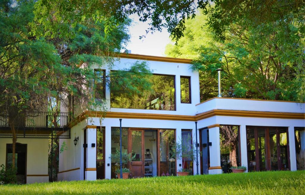 奇莱西托Estancia del Olivo的白色的房子,玻璃门和树木