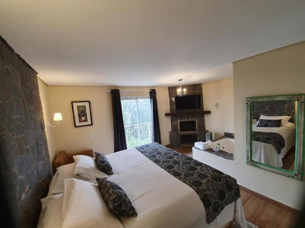 坎波斯杜若尔当窝霍施别墅旅馆的一间卧室配有一张大床和镜子
