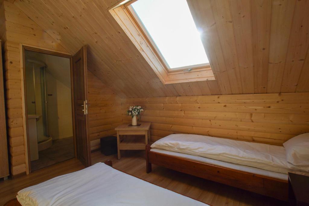Huta SzklanaGórska Chata u Kota的小木屋内一间卧室配有天窗