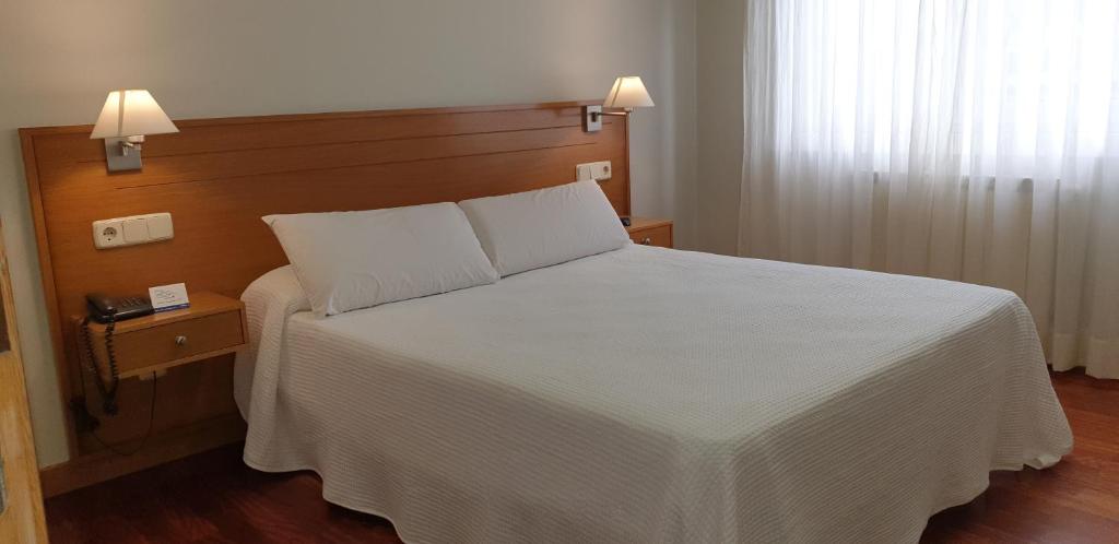 阿尔泰霍阿尔泰修酒店的卧室配有白色的床和2个枕头