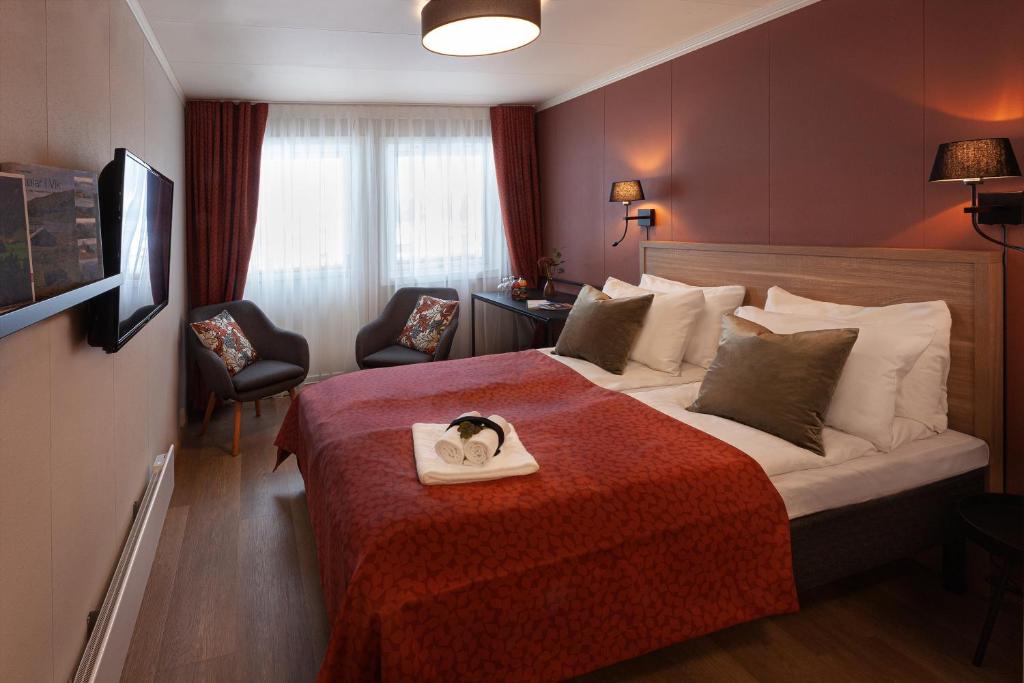 Vikøyri布利克斯酒店的一间酒店客房,配有一张带毛巾的床