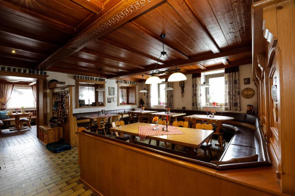 特格尔恩海姆古兹菲尔德潘森酒店的用餐室设有木制天花板和桌椅