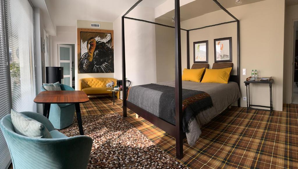 克莱蒙费朗Monts Dôme的卧室配有1张床、1张桌子和1把椅子