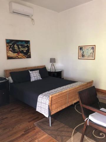 努库阿洛法海滨旅舍的一间卧室配有一张床和一把椅子