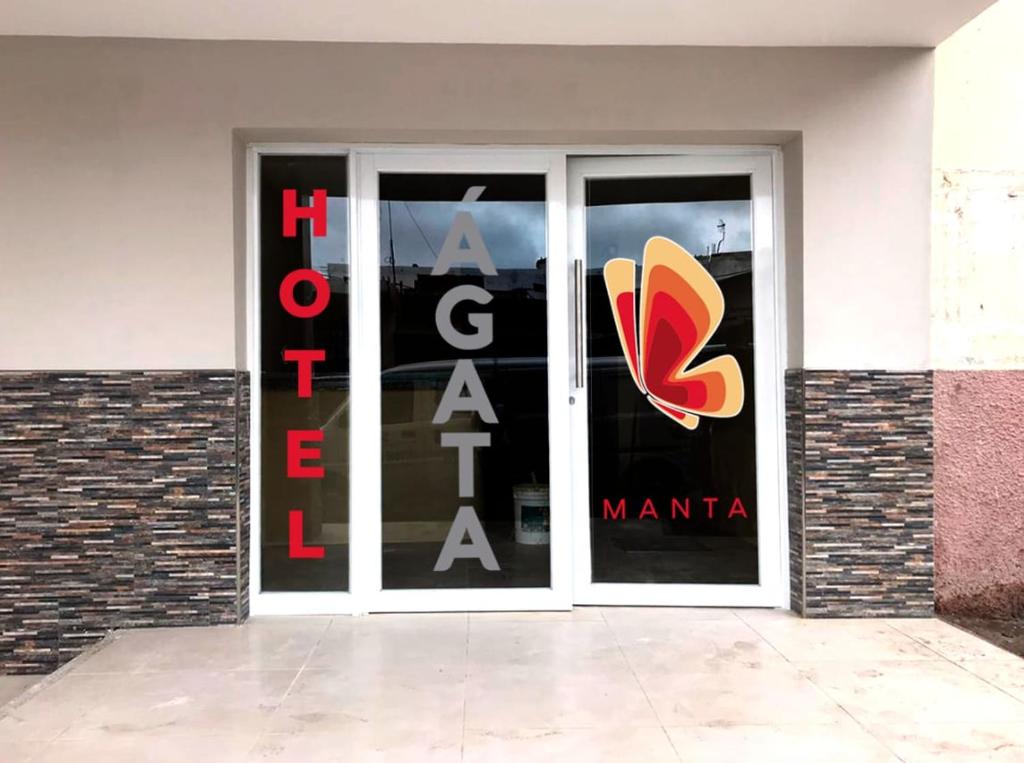 曼塔Hotel Ágata Manta的商店前方有大玻璃门,上面有鞋