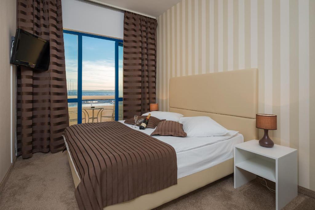 斯普利特嘉德安酒店的一间卧室设有一张床和一个大窗户