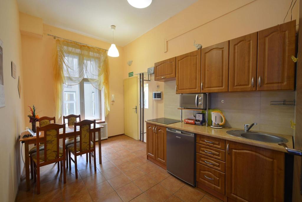 罗兹Apartaments Piotrkowska 101的厨房配有木制橱柜和桌椅