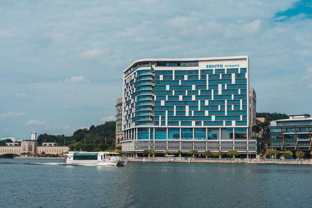 普特拉贾亚Zenith Hotel Putrajaya的靠近水体的蓝色大建筑
