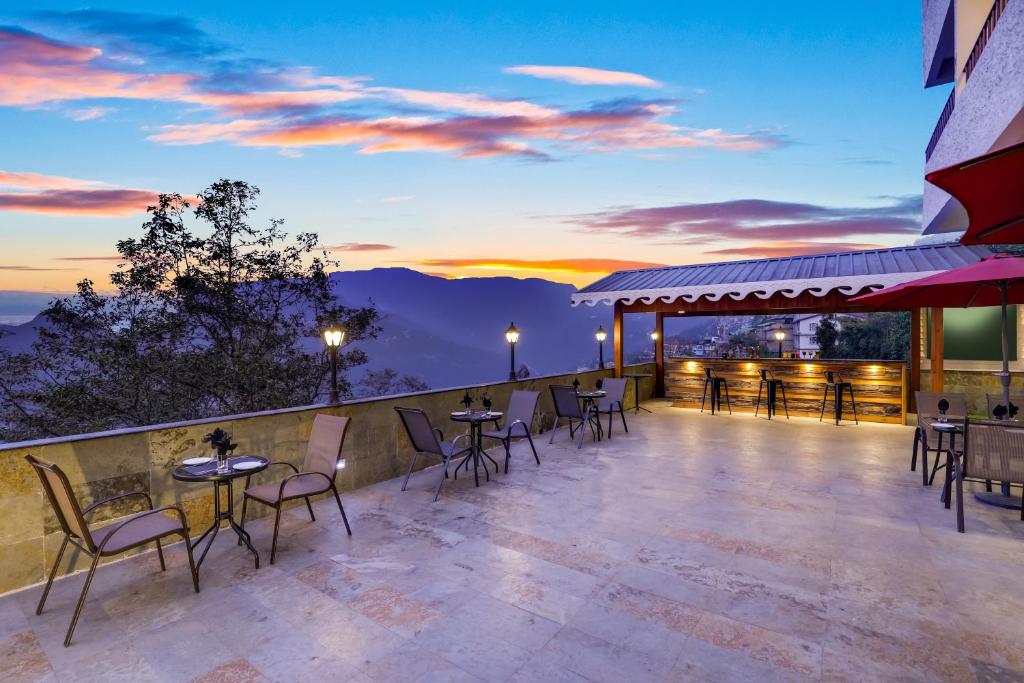 甘托克Mount Himalayan Hotel的露台配有桌椅,享有日落美景
