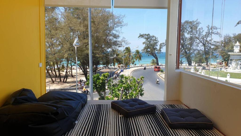 卡伦海滩Fishtail Hostel Phuket的客房设有大窗户,享有街道的景色