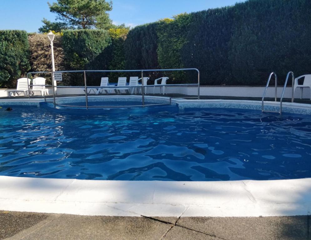 陶因Springside Chalet20的游泳池里设有蓝色的水和白色的椅子