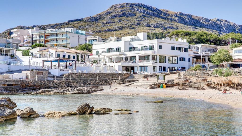 卡拉圣维森特霍坡萨尼乌酒店的一群在海滩上靠近水体的建筑物