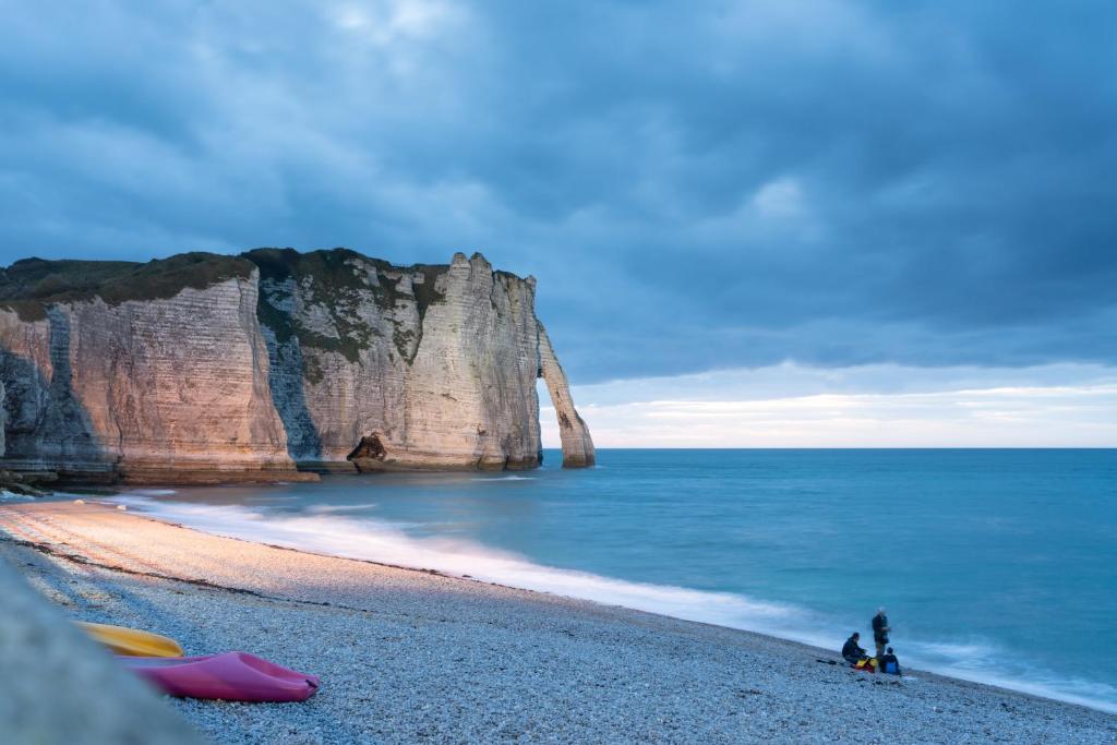 沃勒莱罗斯VVF Normandie Veules-les-Roses的一群人坐在海边的海滩上