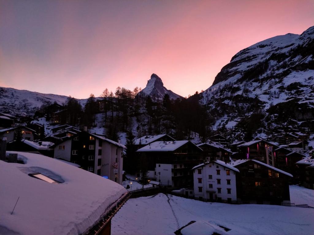 采尔马特Chalet-style Apartment with Matterhorn View的被雪覆盖的村庄,背景是山