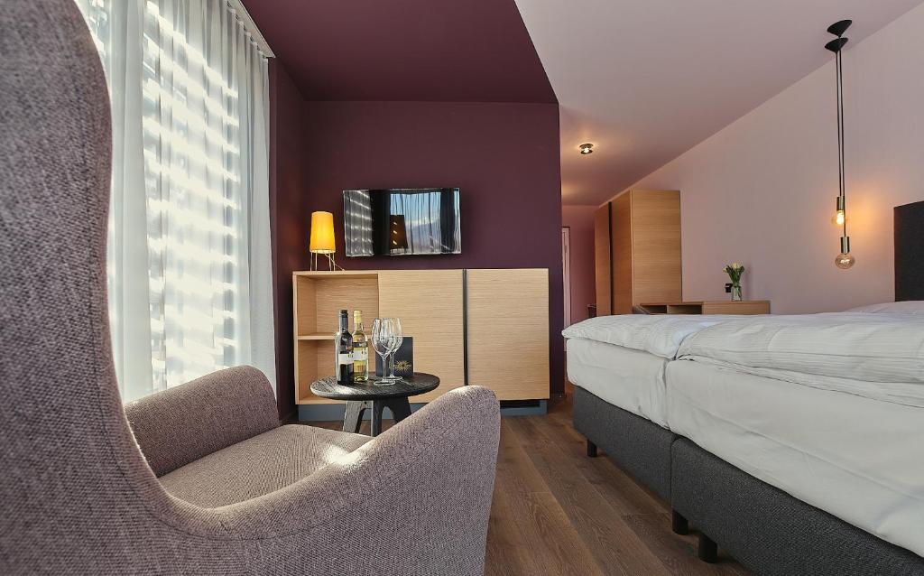 苏斯坦Links Leuk Golfresort的一间卧室配有一张床、一把椅子和一张桌子