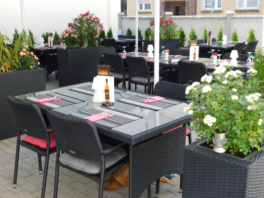 克滕安哈尔特酒店的一间带桌椅和鲜花的用餐室