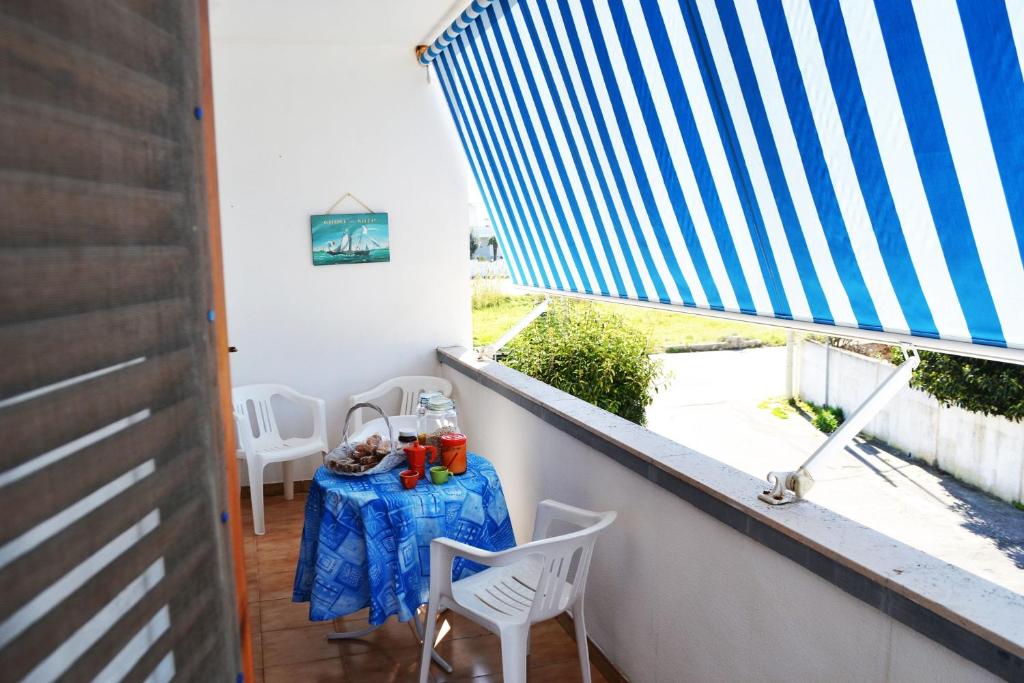 新福卡Casa vacanza vicino spiaggia-ll23的阳台配有桌椅和窗户。