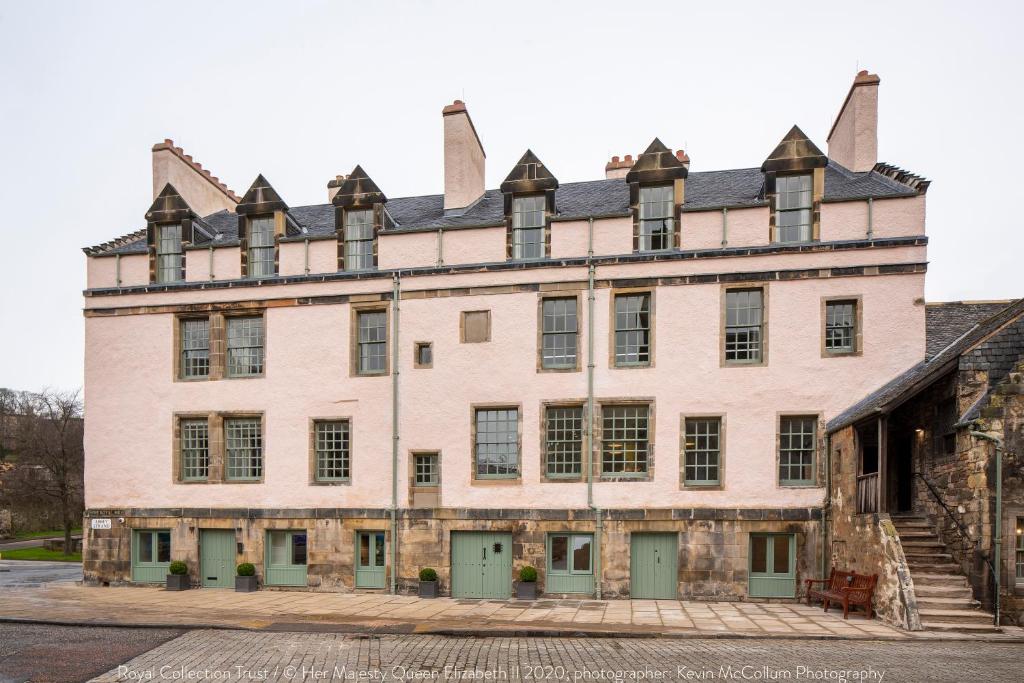 爱丁堡仕骅廷荷里路德艾比史坦公寓酒店的一座带绿门和窗户的大型砖砌建筑