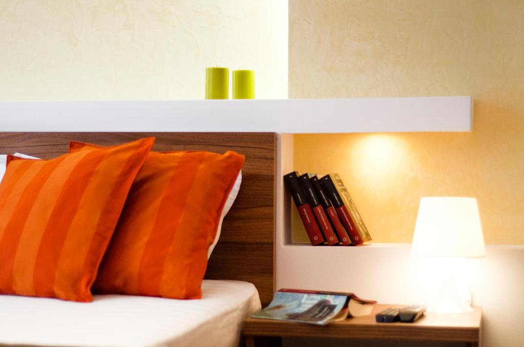 普雷代亚尔6 Apartments的一张带橙色枕头的床和一张带台灯的桌子