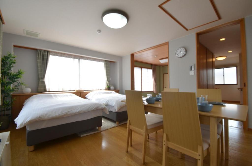 高松Takamatsu - House / Vacation STAY 38164的一间卧室配有两张床和一张桌子及椅子