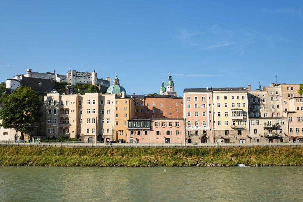 萨尔茨堡老生蓝色丽笙酒店的一群靠近水体的建筑物