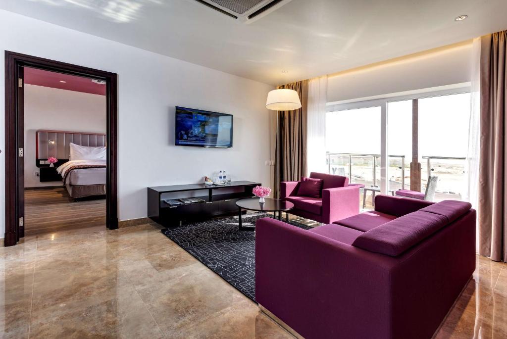 杜科姆杜克丽柏酒店的一间带紫色沙发的客厅和一间卧室