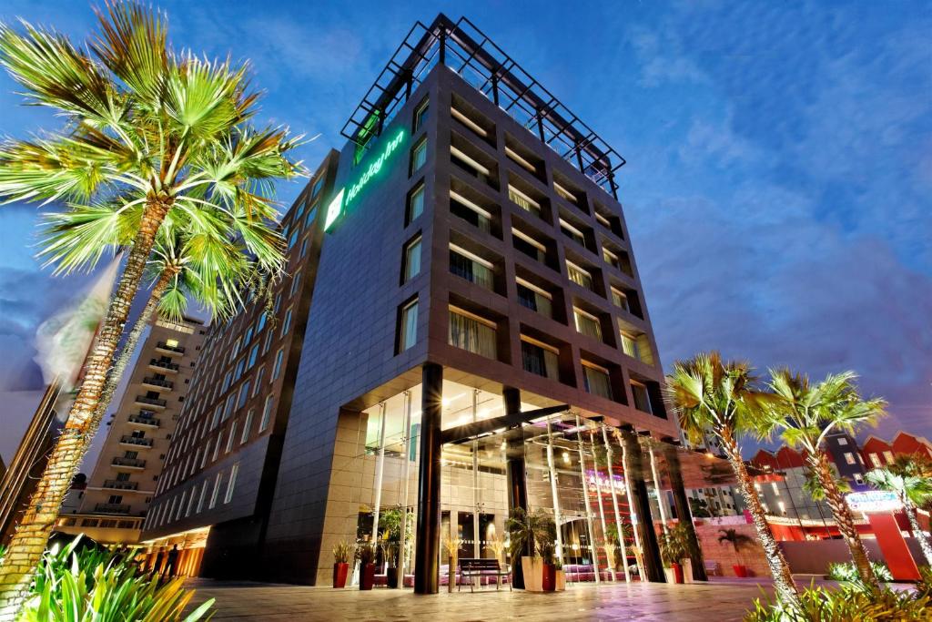 圣多明各Holiday Inn Santo Domingo, an IHG Hotel的一座楼前有棕榈树的酒店