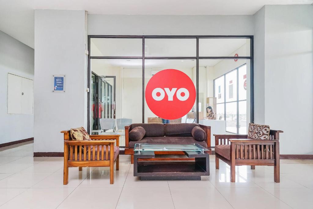 万隆Super OYO Capital O 483 Tamansari Panoramic Bandung的客厅配有沙发和两把椅子