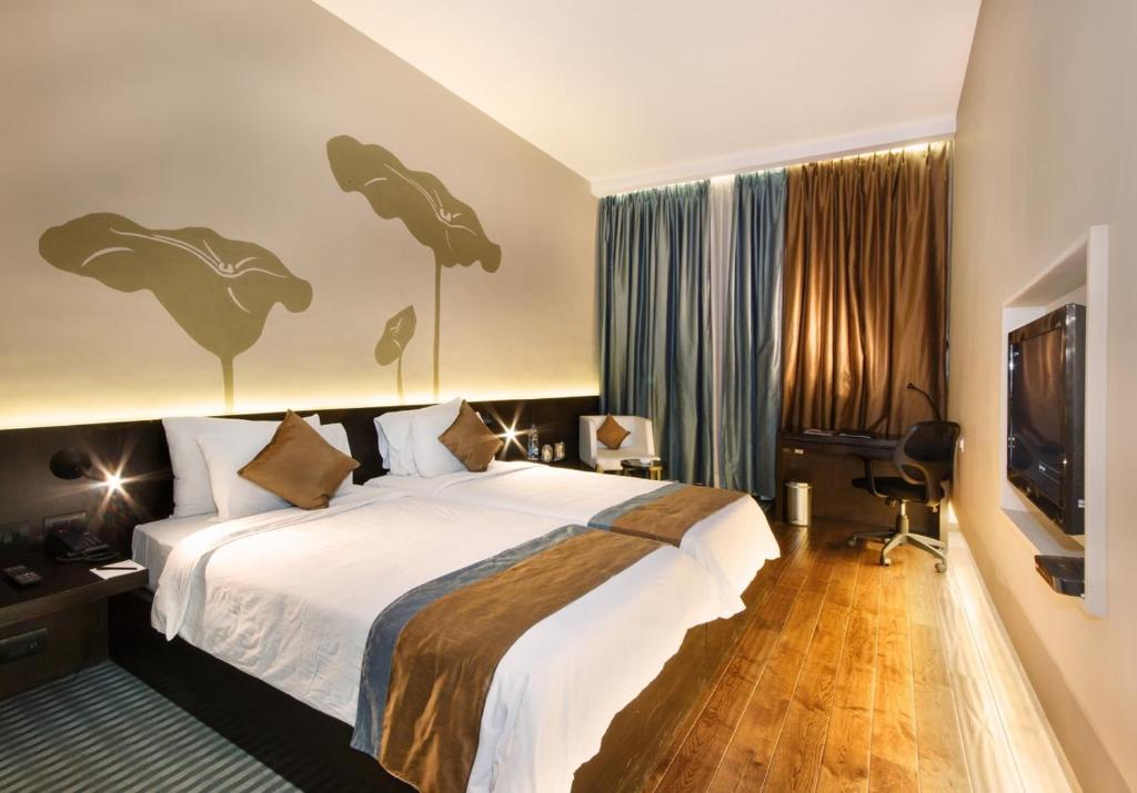 加尔各答Ecohub的配有一张床和一台平面电视的酒店客房